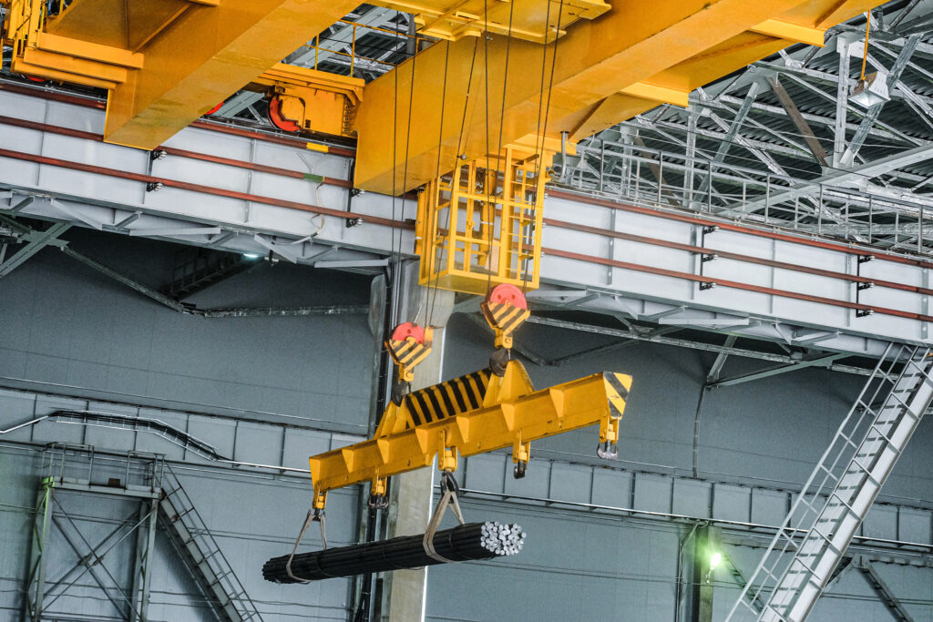 Industrielle Krananlage mit gelbem Brückenkran in einer Produktionshalle